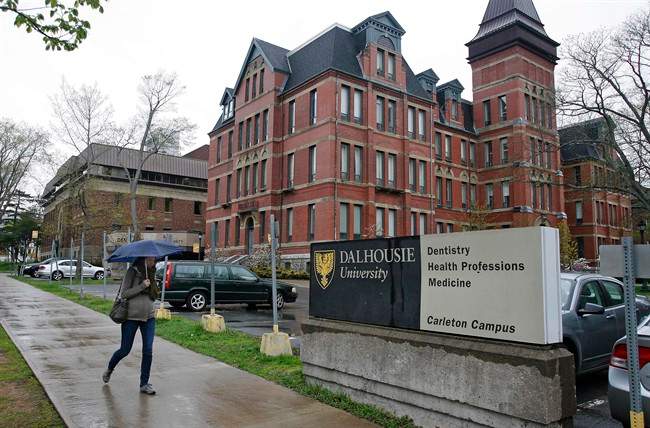 A pedestrian walks by the Dalhousie Dentistry Building in Halifax on Friday, May 22, 2015. A report into sexist online posts by dentistry students at Dalhousie University has found that a Facebook page at the centre of the scandal began as a bonding exercise, but turned offensive. Despite the report's findings, the university says the academic standards class committee determined the men are eligible to graduate as long as they satisfy their clinical requirements. 