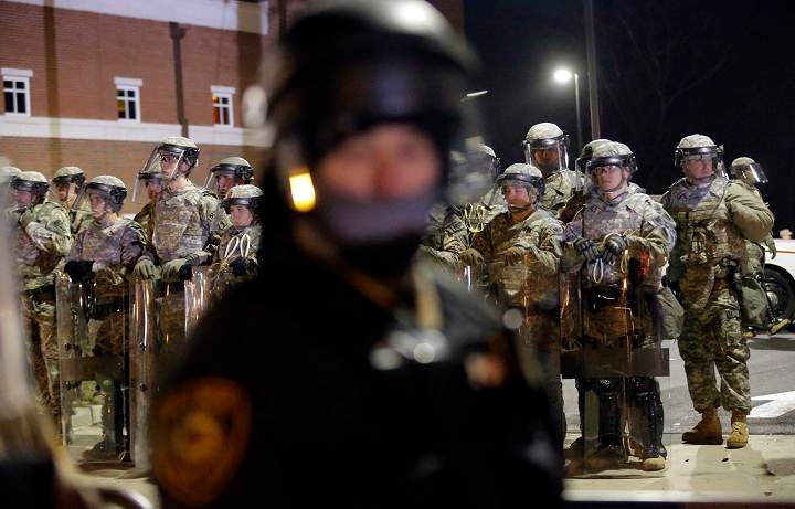 Missouri National Guard line up behind police officers monitoring protesters in front of the Ferguson Police Department Tuesday, Nov. 25, 2014, in Ferguson, Mo. Missouri’s governor ordered hundreds more state militia into Ferguson on Tuesday, after a night of protests and rioting over a grand jury’s decision not to indict police officer Darren Wilson in the fatal shooting of Michael Brown, a case that has inflamed racial tensions in the U.S.