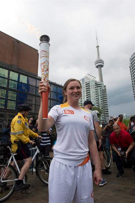 Trampoline gymnast Rosannagh "Rosie" MacLennan carries the first Toronto 2015 Pan Am Games torch in Toronto on Saturday, May 30, 2015.