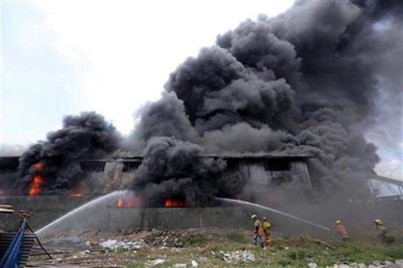 Firemen train their hoses at the burning Kentex footwear factory at Valenzuela city, a northern suburb in Manila, Philippines, Wednesday, May 13, 2015.