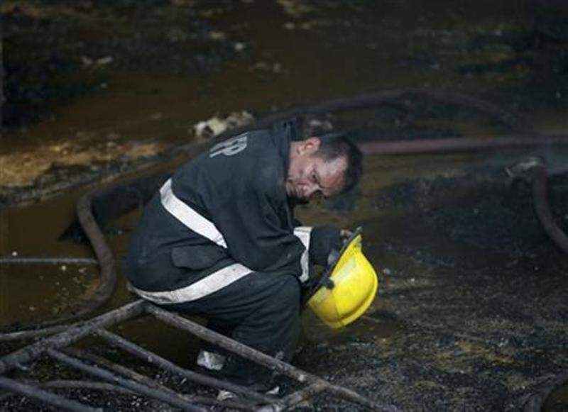 A fireman takes a break following a fire that gutted Kentex rubber slipper factory in Valenzuela city, a northern suburb of Manila, Philippines, Wednesday, May 13, 2015.