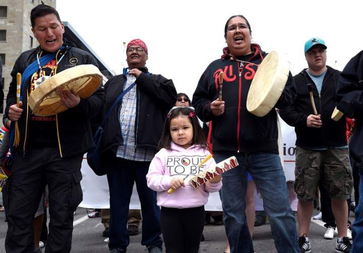Nikamuwin Mianscum, 3, stands with drummers as they lead the Walk for Reconciliation, part of the closing events of the Truth and Reconciliation Commission on Sunday, May 31, 2015 in Ottawa.