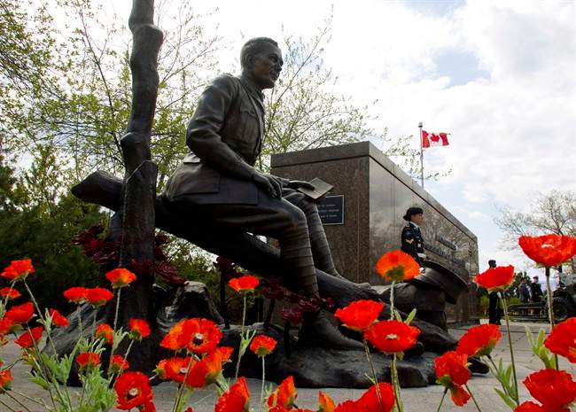 Poppies surround the newly unveiled statue of Lt.-Col. John McCrae to commemorate the Second Battle of Ypres and his poem 'In Flanders Fields,' during a ceremony in Ottawa on Sunday, May 3, 2015. THE CANADIAN PRESS/Fred Chartrand.
