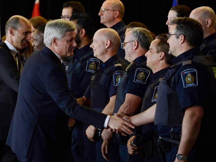 Prime Minister Stephen Harper greets Canada Border Service Agency officers during an announcement in Montreal on Thursday, May 21, 2015.