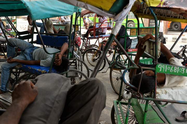 Indian cycle rickshaw riders sleep during the heat of the day in New Delhi on May 28, 2015.