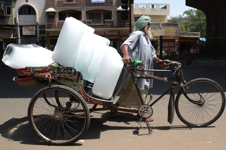 An Indian worker uses a rickshaw to transport ice from an ice factory in Amritsar on May 27, 2015.