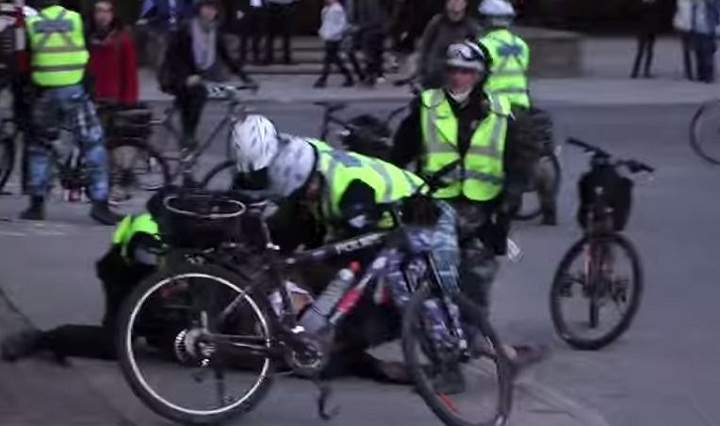A still from a video that surfaced showing a man seemingly being hit in the face by Montreal police officers during May Day demonstrations.