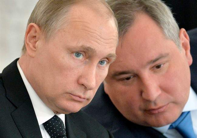 In this March 17, 2015 file photo, Russian President Vladimir Putin, left, and Deputy Prime Minister Dmitry Rogozin attend a meeting of the Victory Day celebrations organizing committee in the Kremlin in Moscow.
