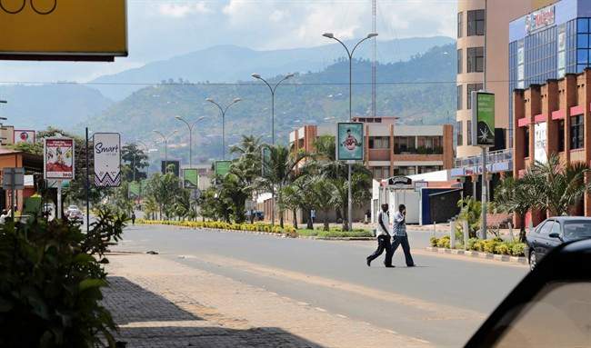 Two men walk across a deserted street in the town center of Bujumbura, Burundi, Friday, May 15, 2015. Two senior army officers and a police general accused of taking part in an attempted coup in Burundi have been arrested, a presidential spokesman said on Friday, as it became apparent that a military plot to oust President Pierre Nkurunziza had fizzled out. 