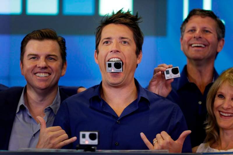 GoPro's CEO Nick Woodman holds a GoPro camera in his mouth as he celebrates his company's IPO at the Nasdaq MarketSite in New York, Thursday, June 26, 2014.