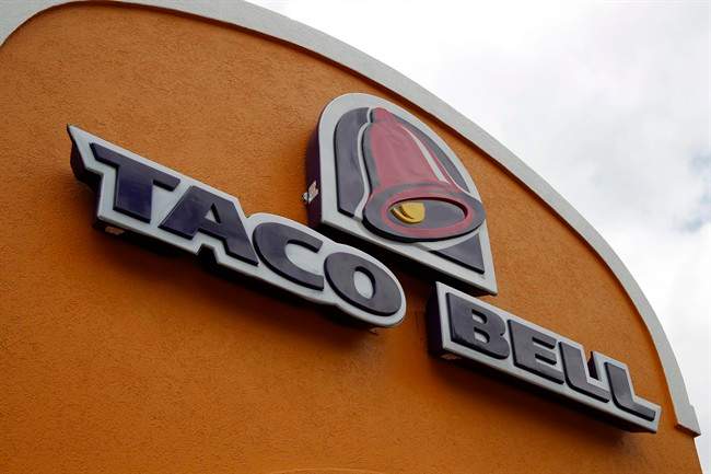 This Friday, May 23, 2014, file photo shows a sign at a Taco Bell in Mount Lebanon, Pa. Taco Bell and Pizza Hut say they're getting rid of artificial colors and flavors, making them the latest big food companies scrambling to distance themselves from ingredients people might find unappetizing.