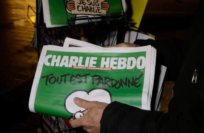  In this Wednesday, Jan. 14, 2015, file photo, a seller of newspapers stocks several “Charlie Hebdo” newspapers at a newsstand in Nice, France. 