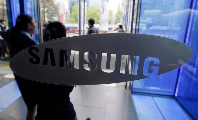 FILE - In this April 29, 2015 file photo, visitors walk by the logo of Samsung Electronics Co. at its showroom in Seoul, South Korea. Samsung wants to sell the digital brains that will go into billions of "smart" home appliances, industrial products and other Internet-connected gadgets — whether those gadgets are made by Samsung or its competitors.