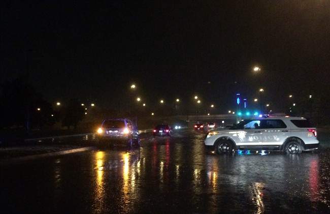 Tulsa police block Riverside Drive because of flooding over the road due to torrential rains on Friday, May 8, 2015 in Tulsa, Oka. The National Weather Service says there's a risk of severe thunderstorms Saturday, including possible tornadoes and large hail, in parts of western Kansas, western Colorado, and the Oklahoma and Texas panhandles. 