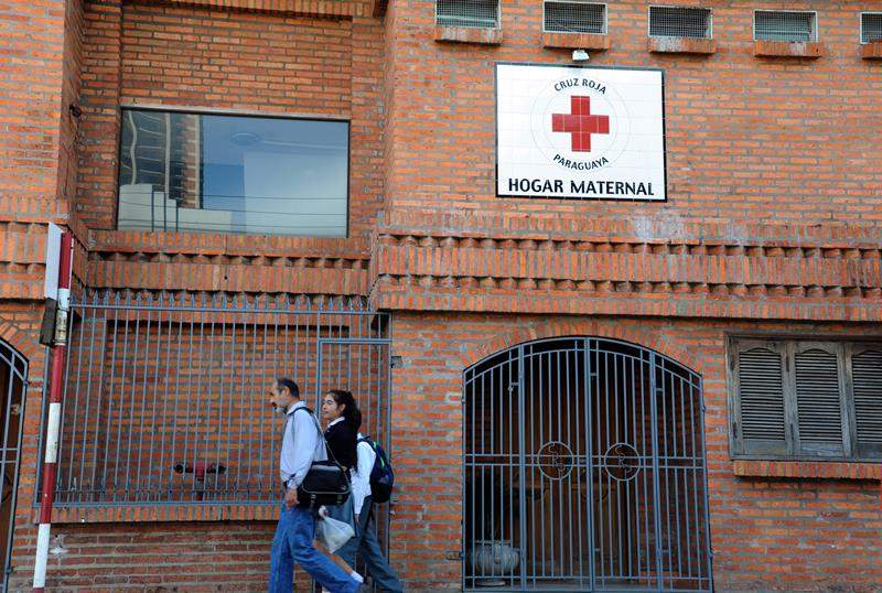 People walk past a maternity home for sexually abused and pregnant girls and teenagers where a 10-year-old who was raped by her stepfather and is now five months pregnant is taken care of in Asuncion on May 8, 2015. The case has become the focal point of a wrenching debate over abortion and child abuse in this conservative Catholic country. 