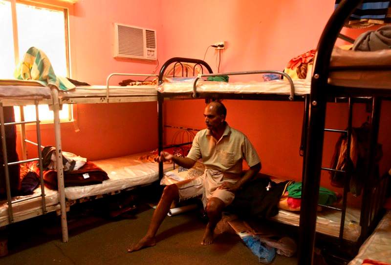  In this Sunday, May 3, 2015 file photo taken during a government organized media tour, Kuttamon Chembadnan Velayi from Kerala, India, speaks to journalists while sitting on his bed in a room he shares with seven other Indian laborers in Doha, Qatar. 