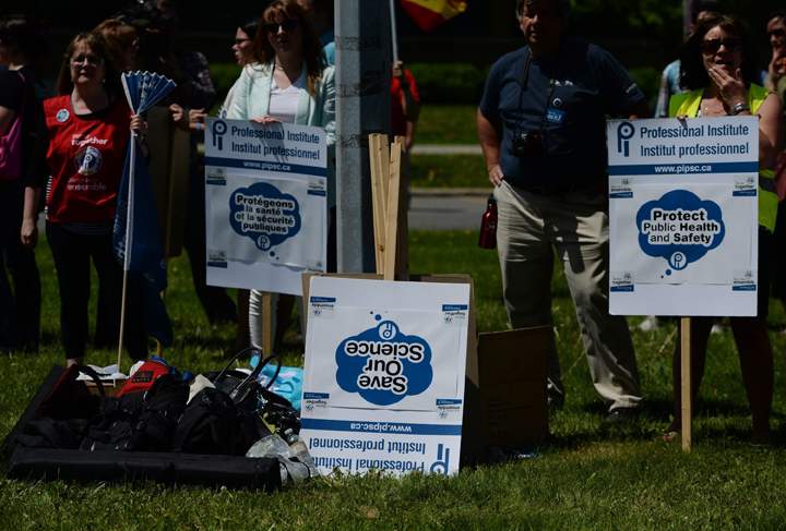 A pile of unused placards sits upside down during a rally at Tunney's Pasture in Ottawa on Tuesday, May 19, 2015. 