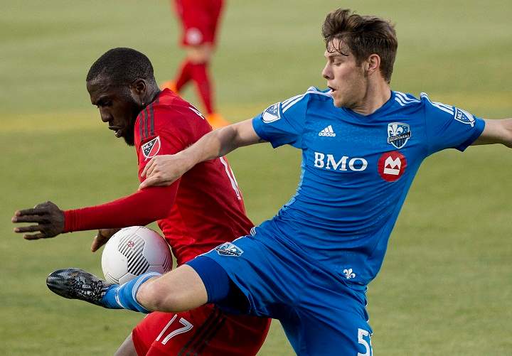Toronto FC Jozy Altidore, left, battles for the ball against Montreal Impact Maxim Tissot, right, during first half semi-final Canadian Championship soccer action in Toronto on Wednesday, May 13, 2015. THE CANADIAN PRESS/Nathan Denette.