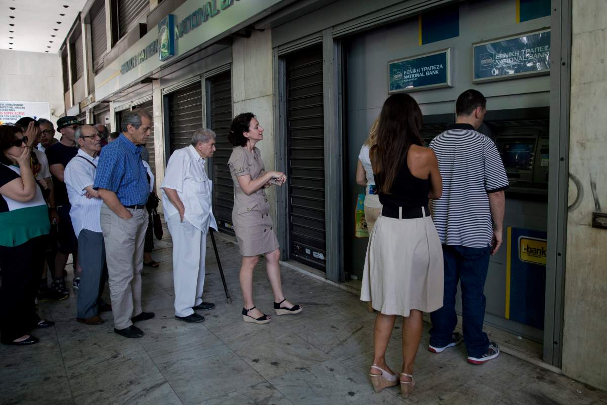 People line up at ATMs outside a National bank branch, in central Athens, Monday, June 29, 2015. (AP Photo/Petros Giannakouris)