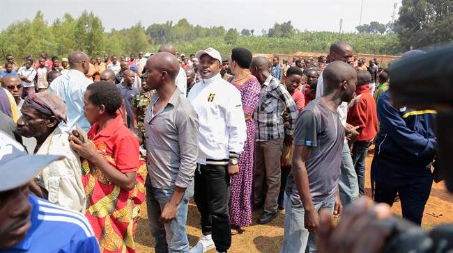 Burundian president Pierre Nkurunziza, centre wearing cap, stands in line to vote in parliamentary elections in Ngozi, Burundi, Monday, June 29, 2015. 