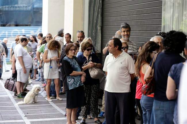 People stand in a queue outside a bank which operates on Saturday but eventually didn\’t open, in central Athens on June 27, 2015.