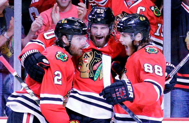 Chicago Blackhawks' Duncan Keith, left, is congratulated by teammates Brandon Saad and Patrick Kane, right, after scoring during the second period in Game 6 of the NHL hockey Stanley Cup Final series on against the Tampa Bay Lightning Monday, June 15, 2015, in Chicago. 
