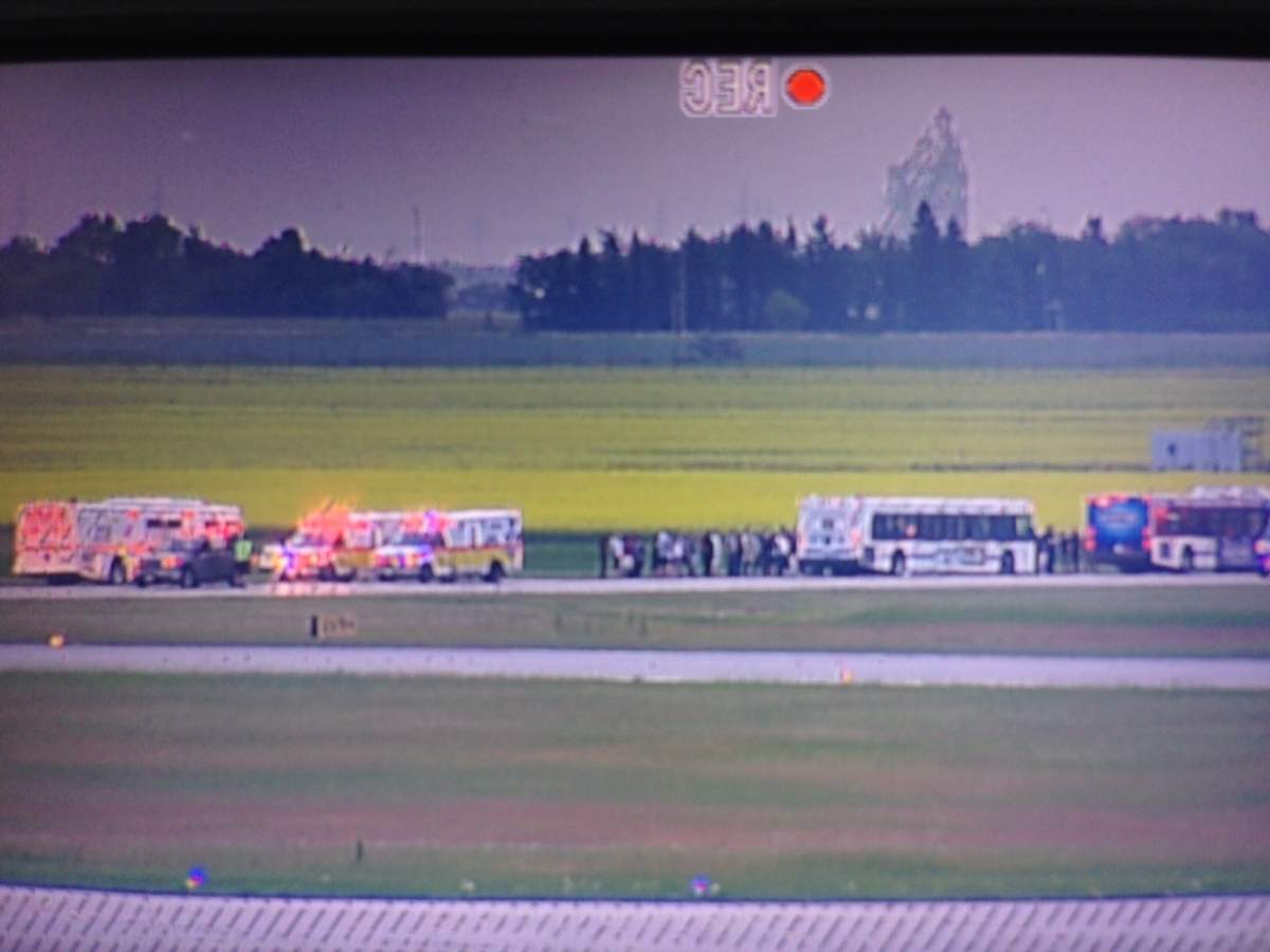 People evacuated form the plane head for shelter in Winnipeg city buses nearby.