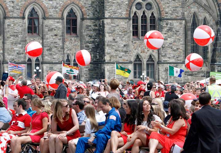 People bounce red and white beach balls during Canada Day celebrations on Parliament Hill, in Ottawa Monday July, 1, 2013.