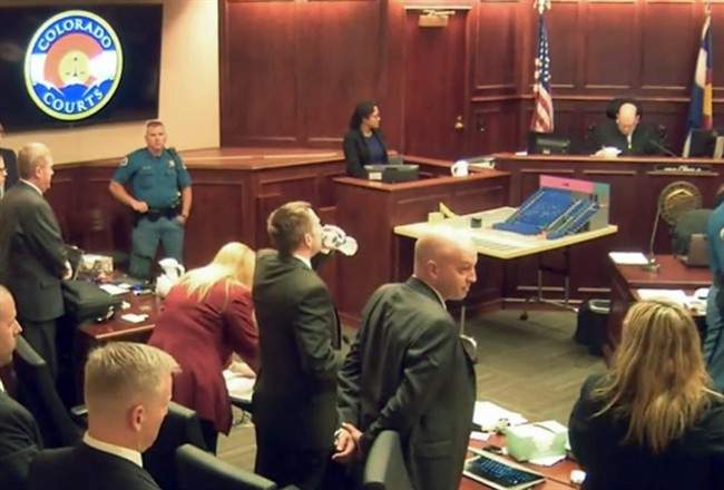 In this image made from a video, the courtroom stands as the jury is excused following Gargi Datta's testimony in a trial for Colorado theater shooter James Holmes, Wednesday, June 10, 2015, in Centennial, Colo.