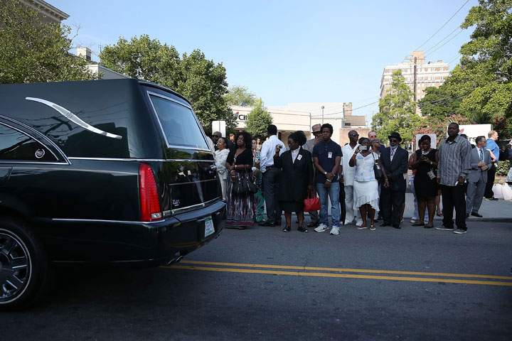 People watch as the hearse carrying South Carolina State Sen. Clementa Pinckney passes by as they line up to enter the College Charleston TD Arena where President Barack Obama is scheduled to deliver the eulogy for Mr. Pinckney who was killed during the mass shooting at the Emanuel African Methodist Episcopal Church along with eight others on June 26, 2015 in Charleston, South Carolina.
