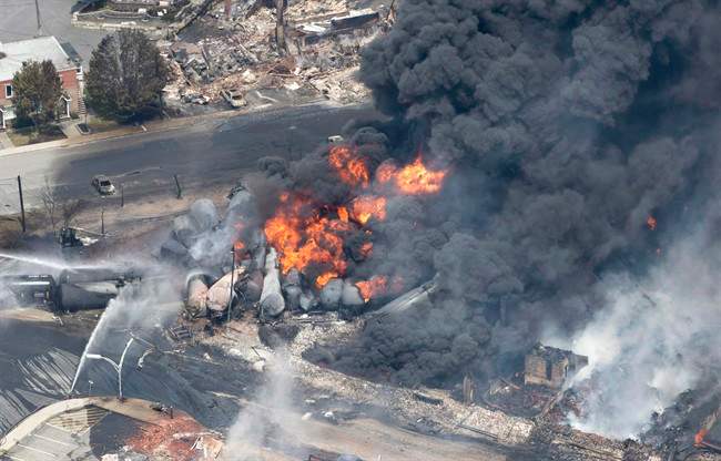 Smoke rises from railway cars that were carrying crude oil after derailing in downtown Lac-Mégantic, Que., on July 6, 2013. The railway at the centre of the disaster will not stand trial the Crown announced on Tuesday, April 3, 2018.