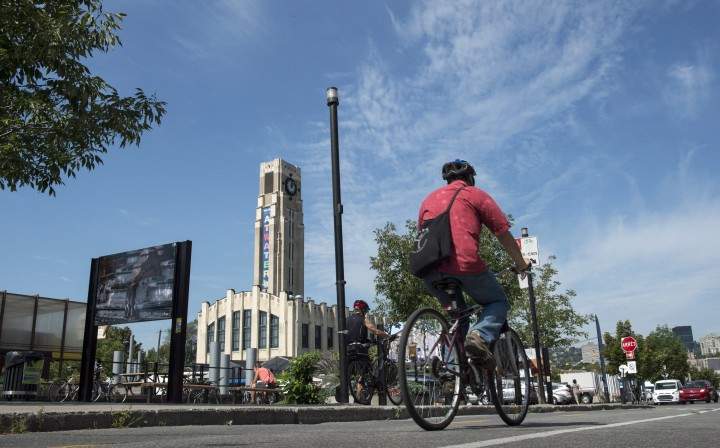 A cyclist rides his bike past the Atwater Market in Montreal.