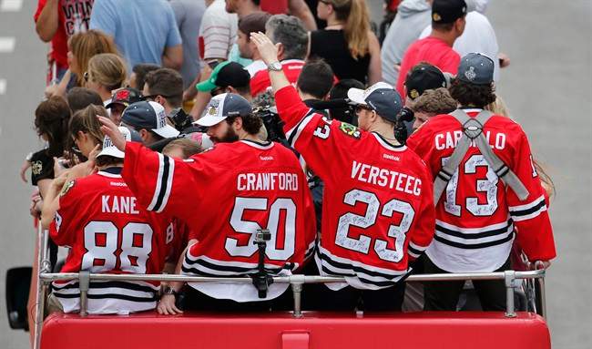 Chicago Blackhawks\’ Patrick Kane (88), Corey Crawford (50), Kris Versteeg (23) and Daniel Carcillo, ride in a parade celebrating the NHL hockey club\’s Stanley Cup championship, Thursday, June 18, 2015, in Chicago. (AP Photo/Charles Rex Arbogast)