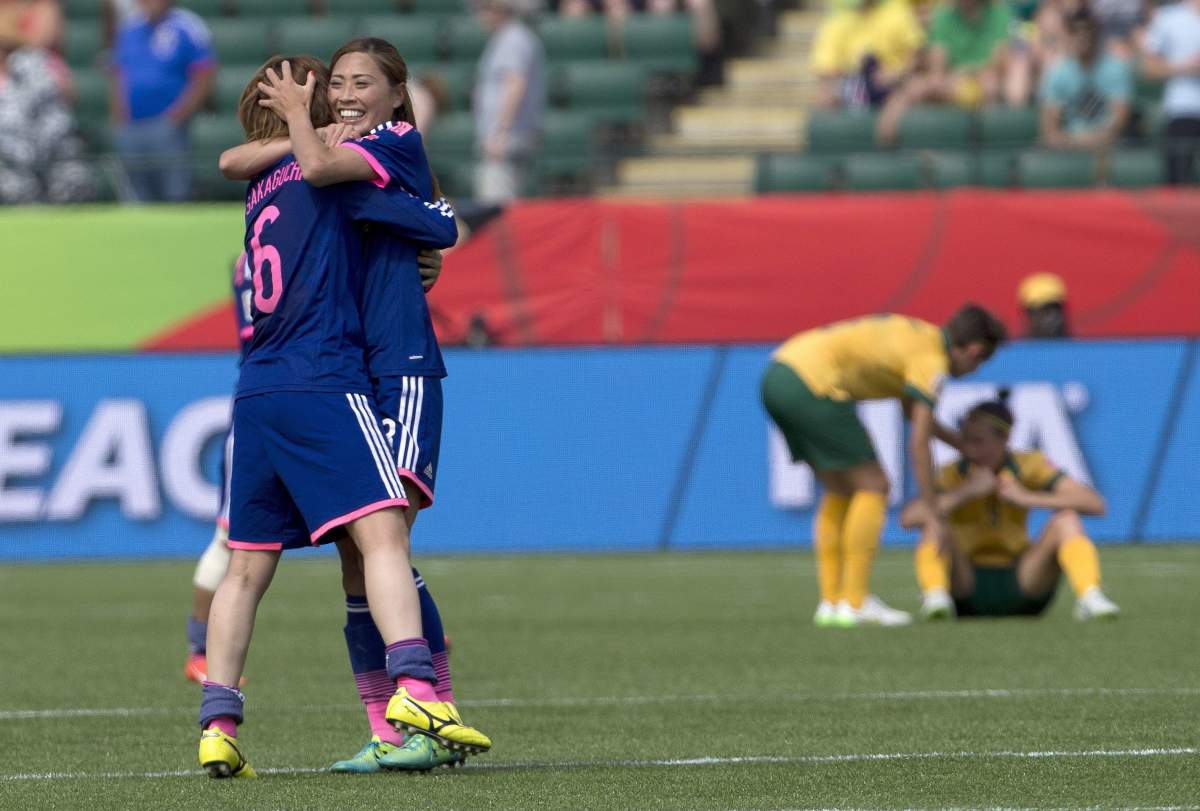 Japan's Mizuho Sakaguchi (6) and Rumi Utsugi (13) celebrate the win over Australia in FIFA Women's World Cup quarter-final action in Edmonton, Alta., on Saturday June 27, 2015. 
