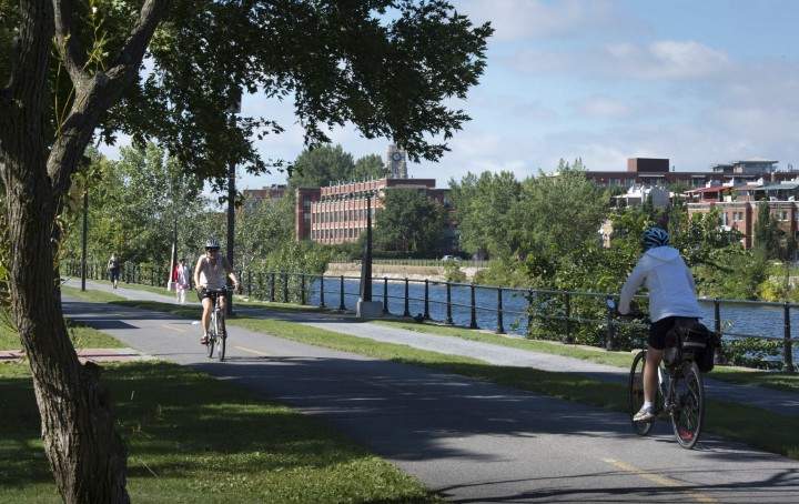 Cyclists ride their bike along the Lachine Canal.