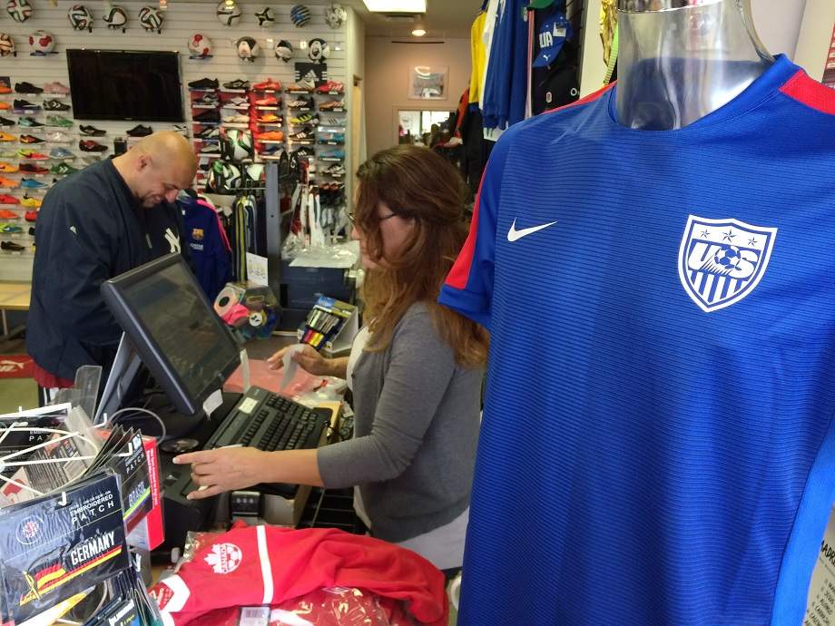Cecilia Castro serves Joe Oliveiria at La Liga as he purchases World Cup gear in preparation of the games.