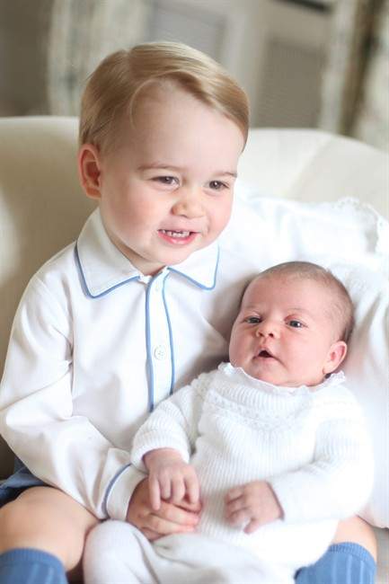 This image made available by Kensington Palace Saturday, June 6, 2015, taken by Kate, Duchess of Cambridge, at Amner Hall, eastern England in mid-May 2015 shows Britain's Princess Charlotte, right, being held by her brother, 2-year-old, Prince George.