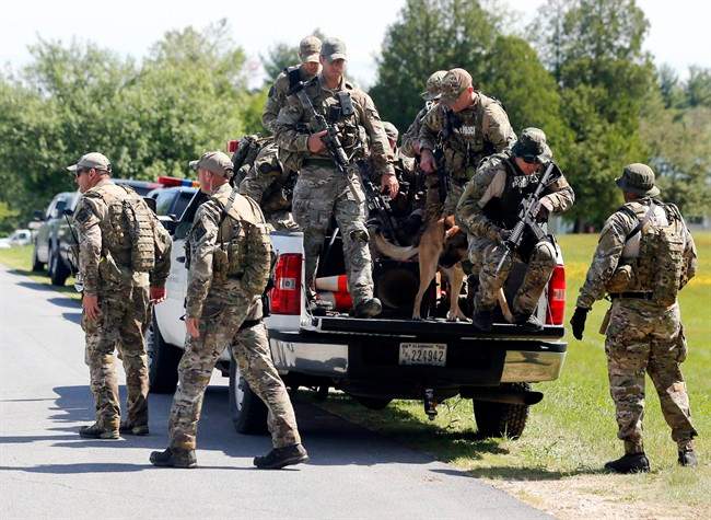 Law enforcement officers get off a truck as they return to their vehicles after searching a wooded area on Sunday, June 14, 2015, in Schuyler Falls,