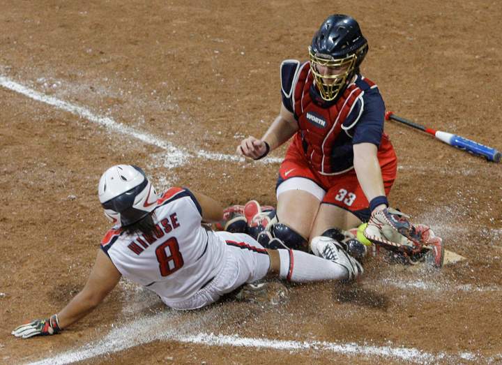 FILE - This is a  Thursday, Aug. 21, 2008. file photo of Japan's Megu Hirose scores as USA catcher Stacey Nuveman tries to apply the tag in the seventh inning in the gold medal softball game in the Beijing 2008 Olympics in Beijing. Japan won 3-1. The sports of Softball and Baseball are hoping to be included into the 2020 Olympic Games. (AP Photo/Elaine Thompson, File).