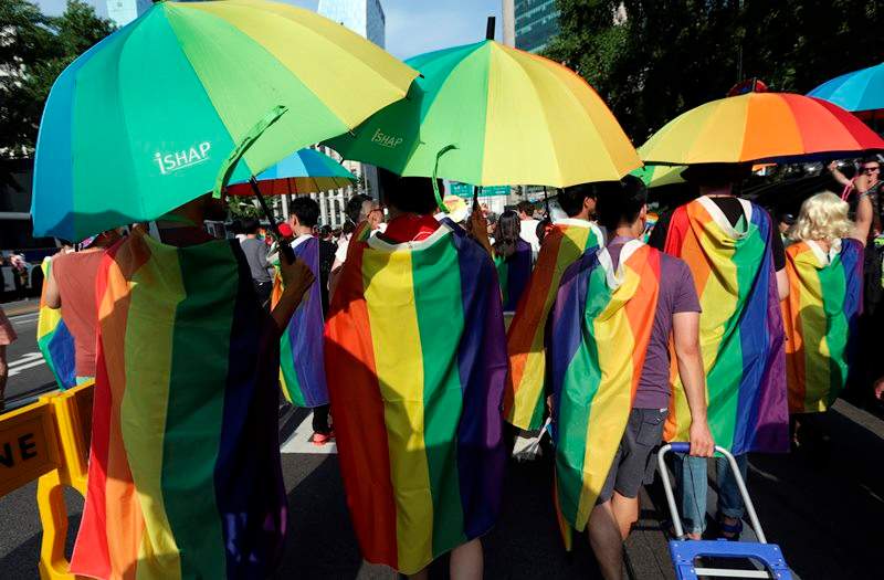 Participants march with rainbow flags and umbrellas during the Korea Queer Festival inSeoul, South Korea, Sunday, June 28, 2015.