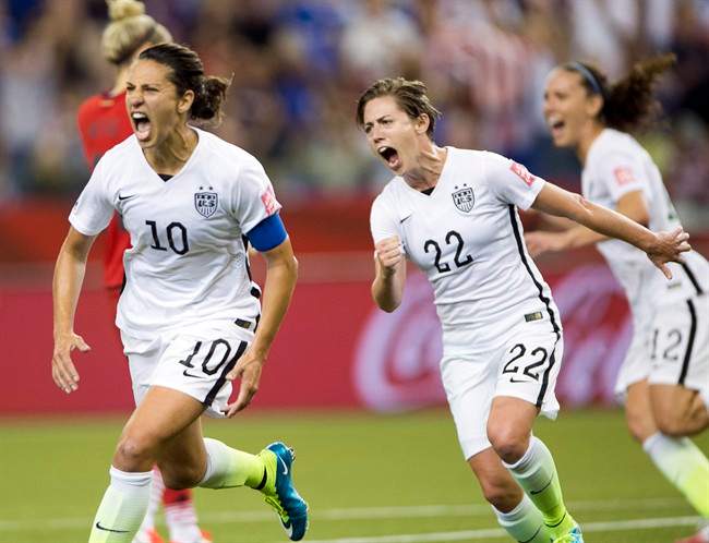 Carli Lloyd (10) reacts after scoring on a penalty kick against Germany as Meghan Klingenberg (22) joins in during second half Women's World Cup semi-final soccer on June 30, 2015.