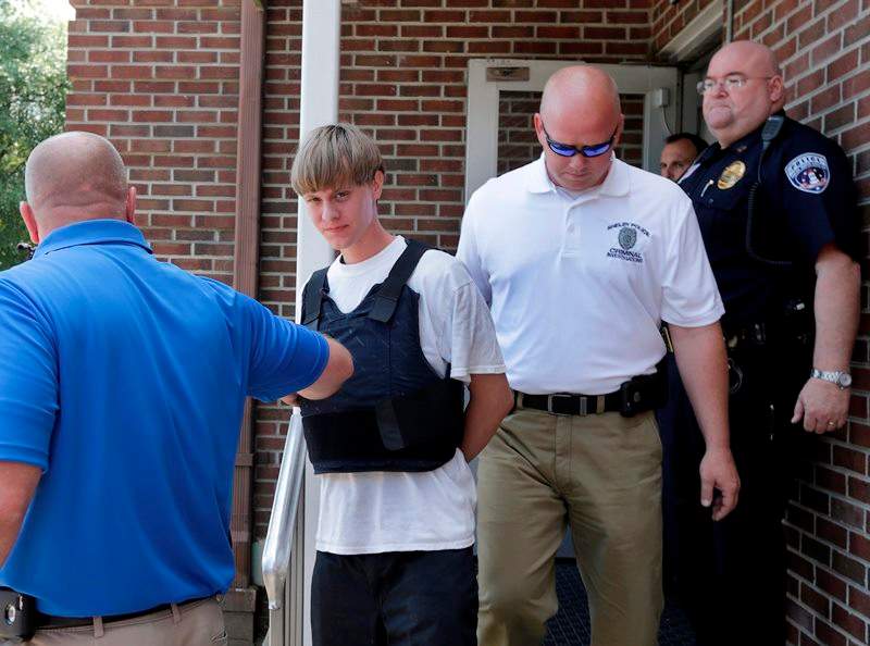 Charleston, S.C., shooting suspect Dylann Storm Roof, center, is escorted from the Shelby Police Department in Shelby, N.C., Thursday, June 18, 2015. Roof is a suspect in the shooting of several people Wednesday night at the historic The Emanuel African Methodist Episcopal Church in Charleston, S.C. 