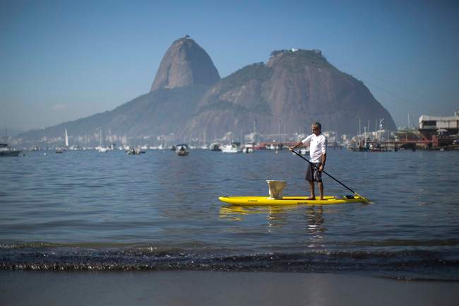 A protester paddles with a toilet atop his board during a demonstration on Botafogo Beach, in the Guanabara Bay in Rio de Janeiro, Brazil, Saturday, June 6, 2015, near where Olympic sailing events are to be held. Activists staged a demonstration on the sewage- and trash-filled strewn Rio de Janeiro beach to protest authorities’ failure to make good on promises to clean up the Olympic city’s filthy waterways ahead of the 2016 games.
