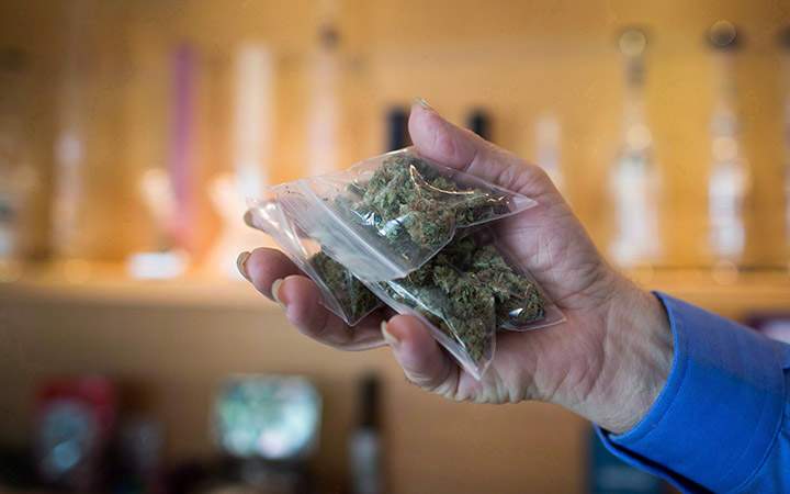 A bag of marijuana is held up at a medical marijuana dispensary in Vancouver on Friday May 1, 2015 THE CANADIAN PRESS/Darryl Dyck.