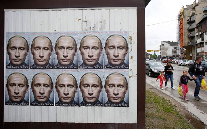 People pass by posters displaying Russian President Vladimir Putin in the town of Bratunac, near Srebrenica on Sunday June, 28, 2015, less than two weeks before the Srebrenica massacre's 20th anniversary.