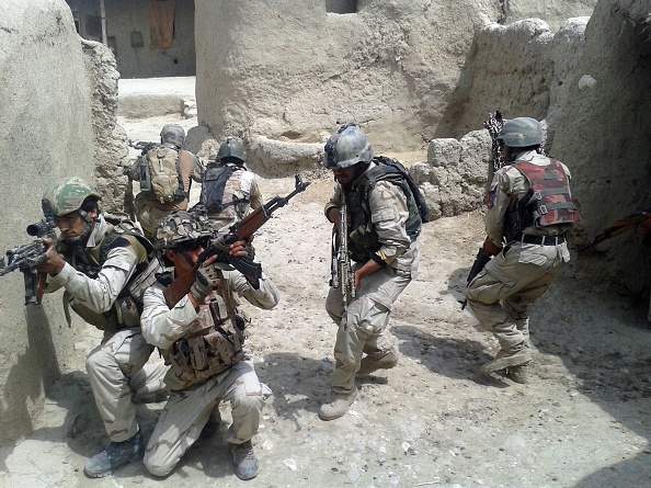 Afghan security forces patrol around the house after they fight against Taliban militants in Almar and Kaysar district of Faryab Province, Afghanistan, on July 22, 2015. At least 14 Taliban militant were killed by Afghan security forces during the clashes. (Photo by Mohammad Hassan Abdullah/Anadolu Agency/Getty Images).
