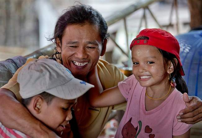 Myint Naing, center, hugs his niece Kyi Wai Hnin, right, and nephew Kyaw Min Tun