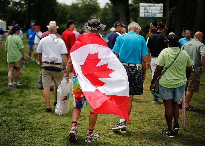 A golf fan wears a Canadian flag while watching the first round of the U.S. Women's Open golf tournament at Lancaster Country Club in Lancaster, Pa., on July 9, 2015. Canadian Open organizers are adding a lot more red and white to the expanse of green at Glen Abbey Golf Club. First-year tournament director Brent McLaughlin heard from players that there's not enough "Canadiana" at the RBC Canadian Open.