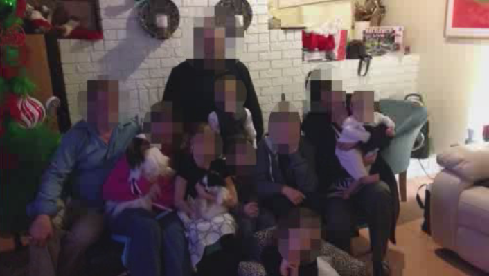 A photo of J.P., some family members, and her four children.