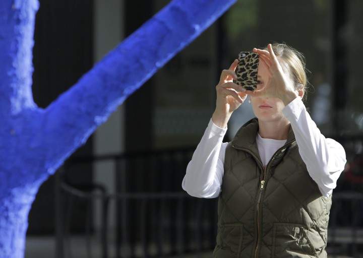 A file photo of a woman taking a picture in a park.
